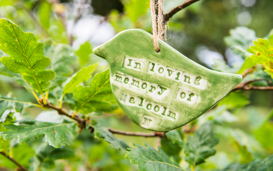 In loving memory plaque hanging off a tree in the Celebration Woods at Wild Haweswater